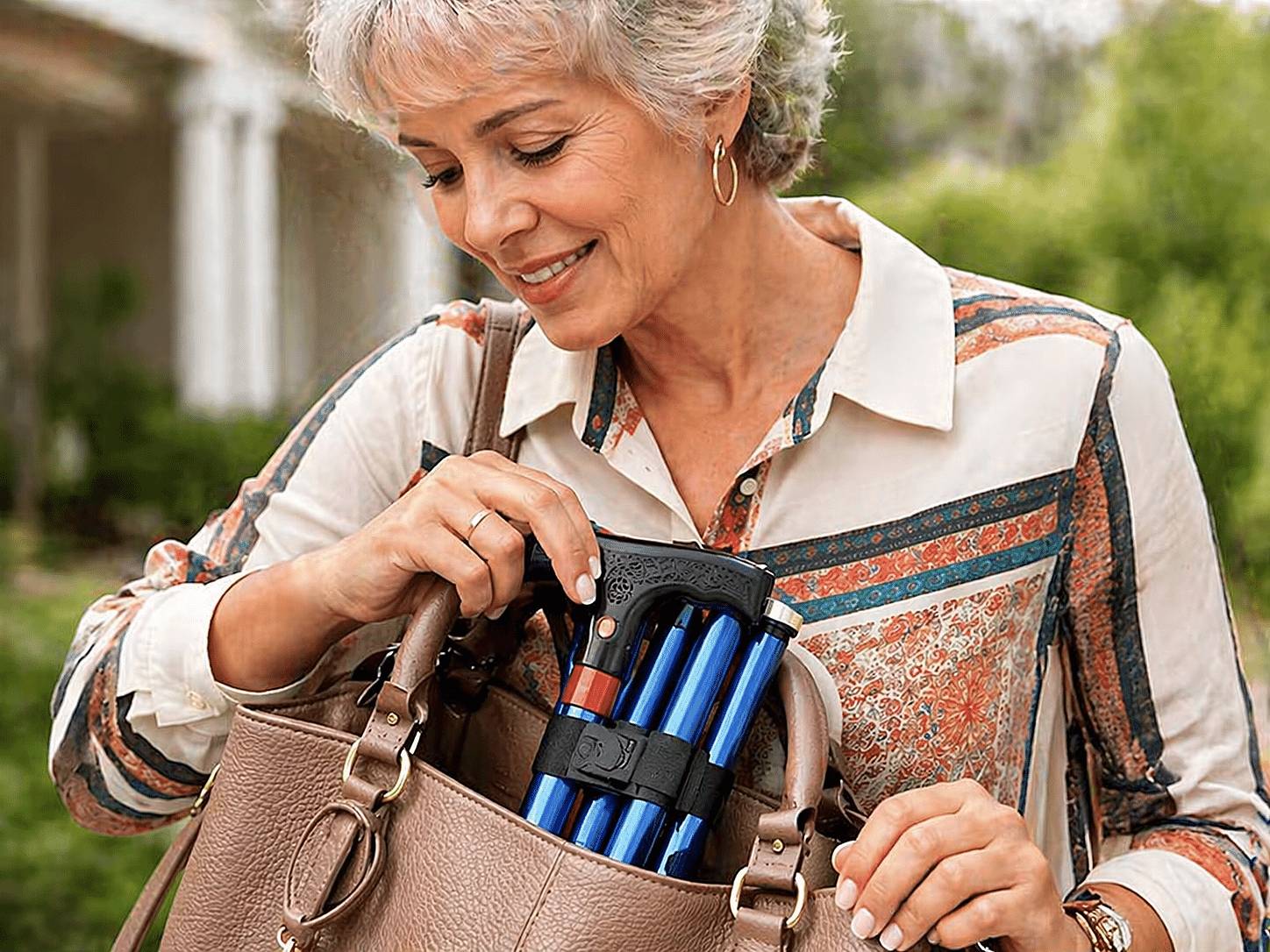 Woman placing folded cane into handbag
