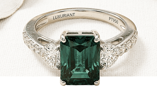 Luxuriant emerald-cut gemstone ring with diamond halo setting in platinum