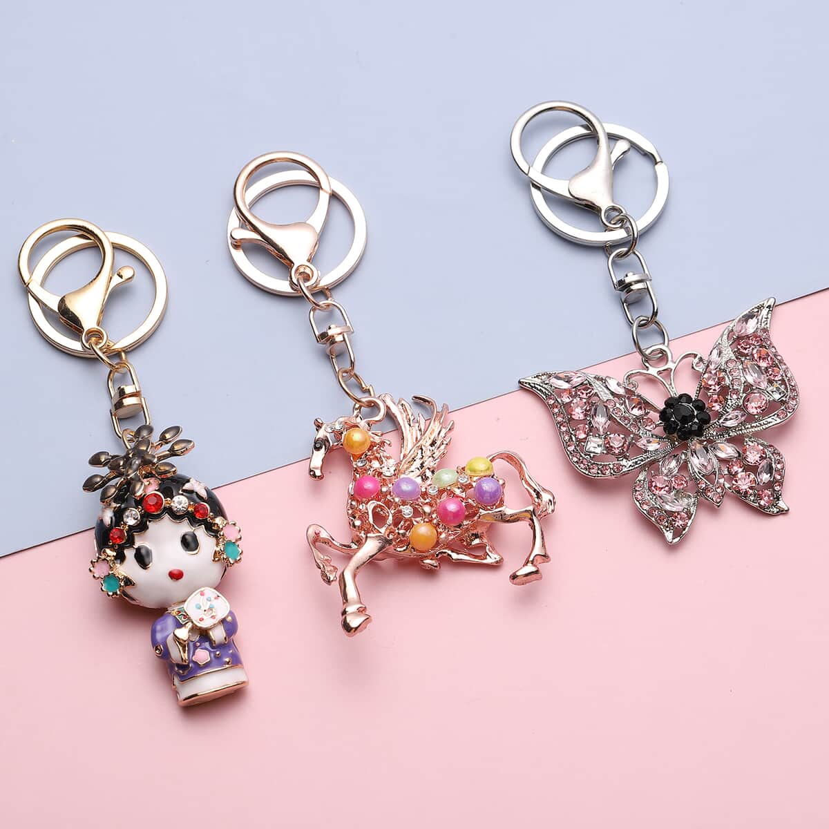 Set of 3 Multi Color Austrian Crystal, Enameled Butterfly, Unicorn and Baby Doll Keychain in Rosetone image number 1