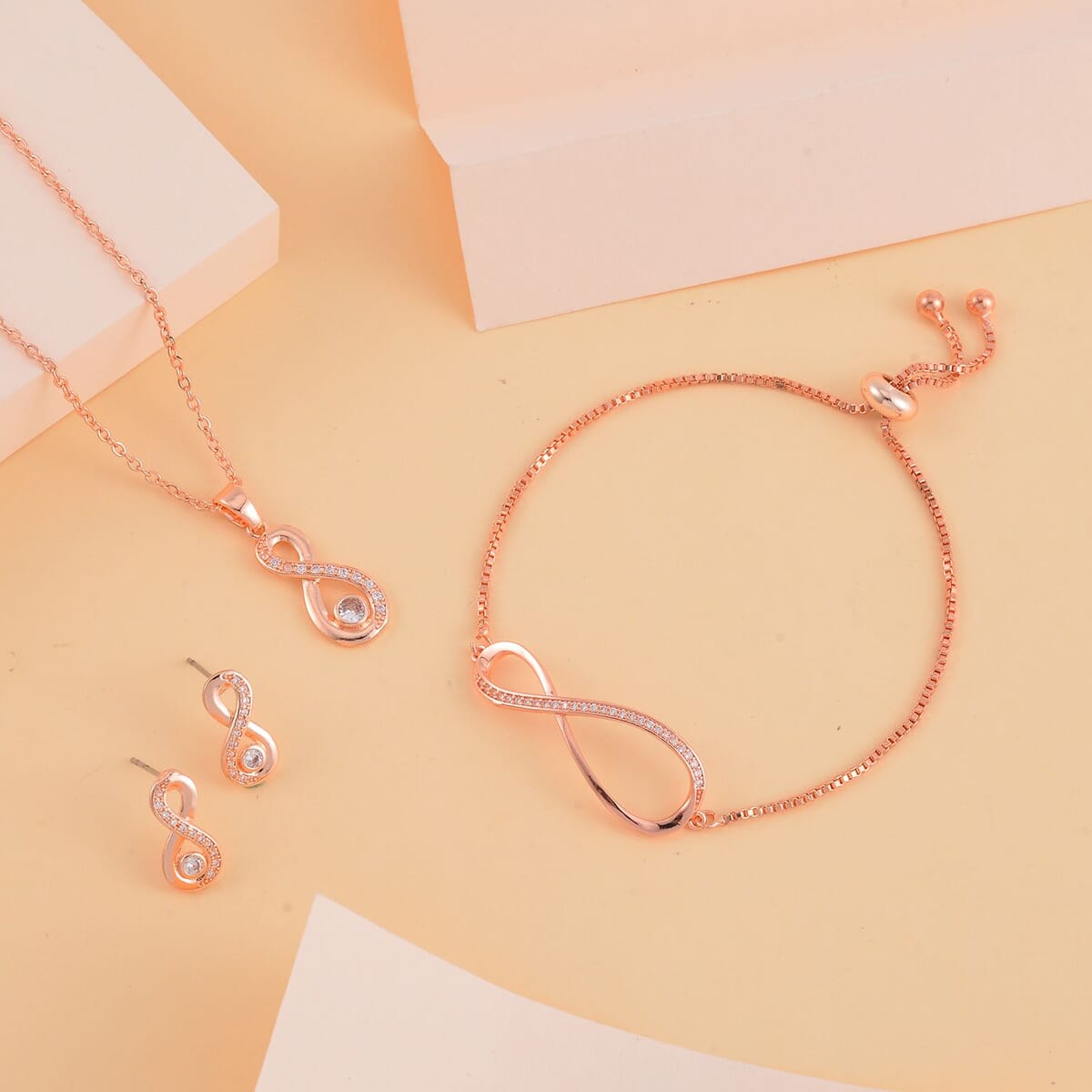 Simulated Diamond Infinity Necklace 20-22 Inches Bolo Bracelet and Earrings in Rosetone 0.50 ctw image number 1