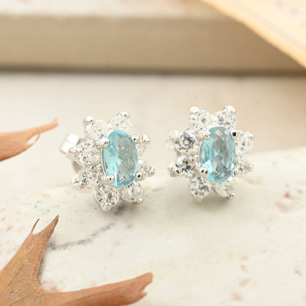 Simulated Blue and White Diamond Halo Stud Earrings in Silvertone image number 1