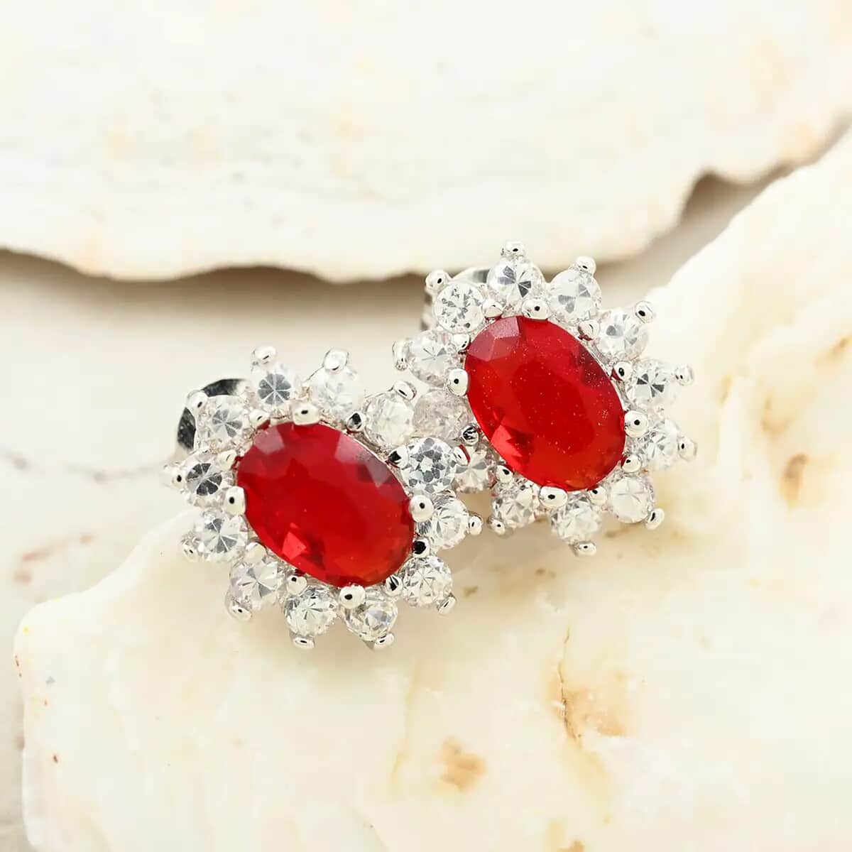 Simulated Red and White Diamond Halo Stud Earrings in Silvertone image number 1