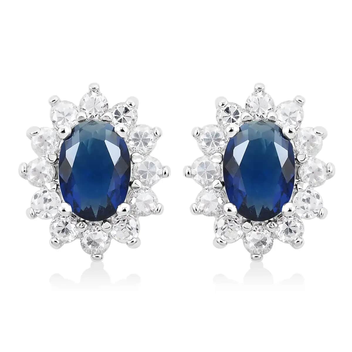 Simulated Blue and White Diamond Halo Stud Earrings in Silvertone image number 0